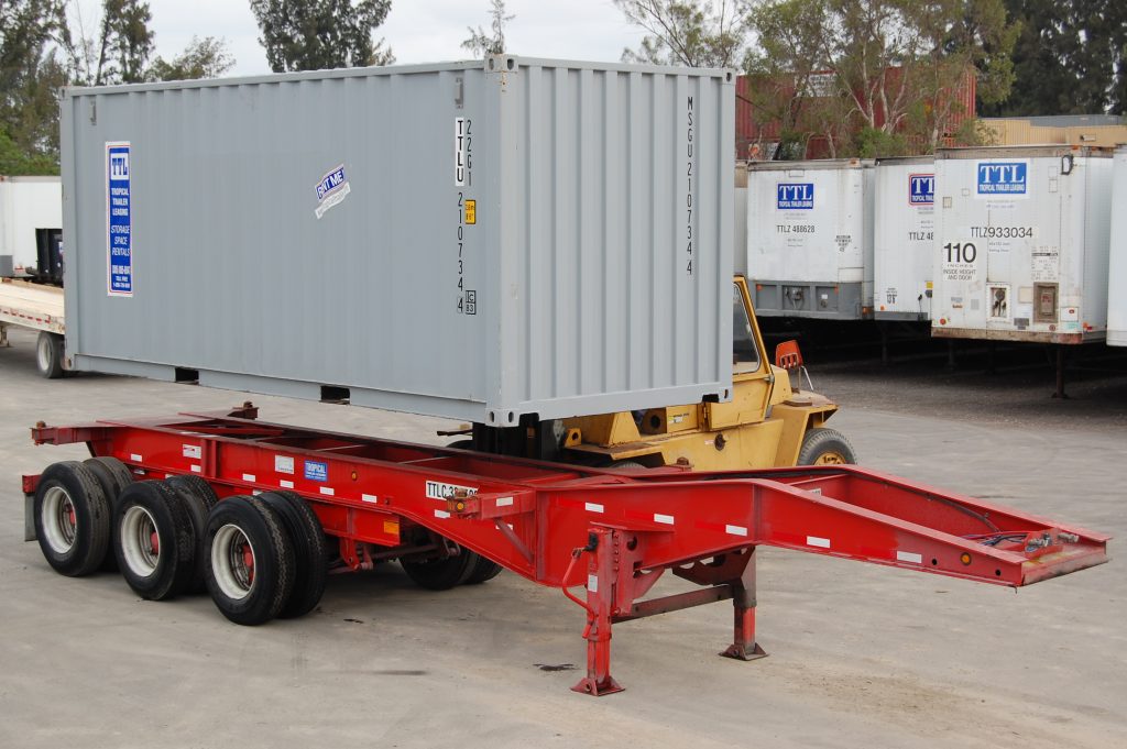 20 Foot shipping container being loaded onto triaxle